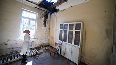 Сотрудница осматривает повреждения после обстрела в городской больнице № 20 в Донецке Сотрудница осматривает повреждения после обстрела в городской больнице № 20 в Донецке