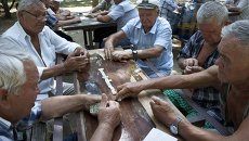 Пенсионеры играют в домино в парке города Евпатория. Архивное фото Пенсионеры играют в домино в парке города Евпатория. Архивное фото