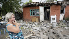 Женщина возле разрушенного во время обстрела дома в Донецке Женщина возле разрушенного во время обстрела дома в Донецке