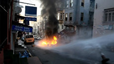 Полицейские водометами тушили горящий мусор во время беспорядков в Стамбуле Полицейские водометами тушили горящий мусор во время беспорядков в Стамбуле