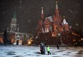 Прохожие во время снегопада на Красной площади в Москве Прохожие во время снегопада на Красной площади в Москве
