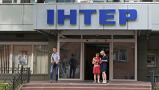 Люди у входа в здание телеканала Интер в Киеве, Украина Люди у входа в здание телеканала Интер в Киеве, Украина