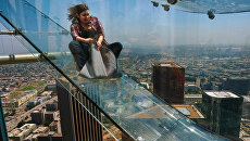 Женщина скользит вниз по Skyslide на внешней стороне Bank Tower в Лос-Анджелесе, США. Июнь 2016 Женщина скользит вниз по Skyslide на внешней стороне Bank Tower в Лос-Анджелесе, США. Июнь 2016