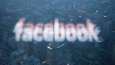Логотип социальной сети Facebook в отражении экрана монитора компьютера в окне/ Архивное фото Логотип социальной сети Facebook в отражении экрана монитора компьютера в окне/ Архивное фото