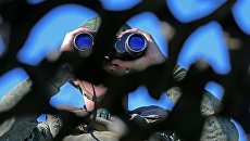 Российский военный смотрит в бинокль. Архивное фото Российский военный смотрит в бинокль. Архивное фото