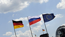 Флаги России, Германии и Евросоюза на фоне Рейхстага в Берлине, Германия. Архивное фото Флаги России, Германии и Евросоюза на фоне Рейхстага в Берлине, Германия. Архивное фото