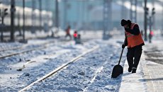 Рабочий очищает железнодорожный путь. Архивное фото Рабочий очищает железнодорожный путь. Архивное фото