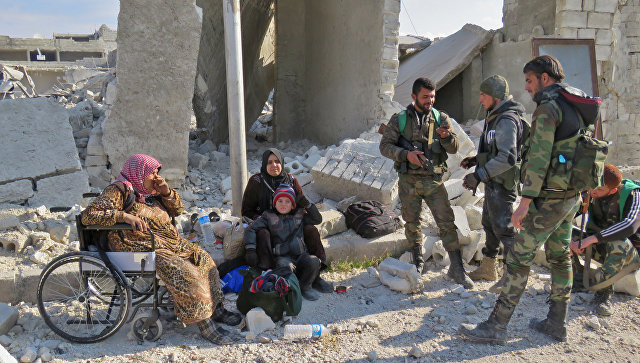 Солдаты правительственных войск и местные жители в одном из освобожденных от боевиков районов Алеппо, Сирия. 12 декабря 2016