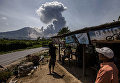 Индонезийские жители смотрят на извержение вулкана Синабунг Индонезийские жители смотрят на извержение вулкана Синабунг