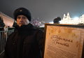 Сотрудник правоохранительных органов демонстрирует подорожную грамоту для проезда специального автопоезда с главной Новогодней елкой России на территорию московского Кремля Сотрудник правоохранительных органов демонстрирует подорожную грамоту для проезда специального автопоезда с главной Новогодней елкой России на территорию московского Кремля
