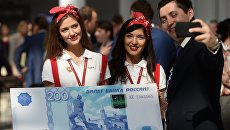 Мужчина фотографируется с образцом банкноты в 200 рублей на международном инвестиционном форуме Сочи 2016 Мужчина фотографируется с образцом банкноты в 200 рублей на международном инвестиционном форуме Сочи 2016