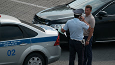 Сотрудник ДПС проверяет документы у водителя. Архивное фото Сотрудник ДПС проверяет документы у водителя. Архивное фото