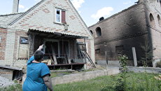 Местная жительница возле дома, пострадавшего от минометного артобстрела поселка Александровка в Донецкой области. 22 июня 2017 Местная жительница возле дома, пострадавшего от минометного артобстрела поселка Александровка в Донецкой области. 22 июня 2017