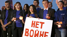 Молодые люди с плакатом Нет войне. Архивное фото Молодые люди с плакатом Нет войне. Архивное фото