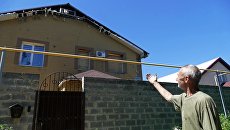 Мужчина у здания, поврежденного в результате обстрела, в Донецке. 18 июля 2017 Мужчина у здания, поврежденного в результате обстрела, в Донецке. 18 июля 2017