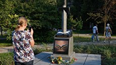 Женщина фотографирует памятник украинским военным, погибшим в Донбассе Женщина фотографирует памятник украинским военным, погибшим в Донбассе