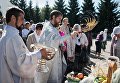 Священнослужитель окропляет святой водой яблоки и фрукты во время богослужения в честь праздника Преображения Господня у собора Воздвижения Креста Господня в Омске. 19 августа 2017 Священнослужитель окропляет святой водой яблоки и фрукты во время богослужения в честь праздника Преображения Господня у собора Воздвижения Креста Господня в Омске. 19 августа 2017