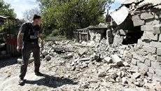 Сотрудник ОБСЕ осматривает двор жилого дома, пострадавший в результате обстрела Докучаевска в Донецкой области. Архивное фото Сотрудник ОБСЕ осматривает двор жилого дома, пострадавший в результате обстрела Докучаевска в Донецкой области. Архивное фото