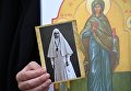 Участница VI Елисаветинского крестного хода с фотографией великой княгини Елизаветы Федоровны во время переправы через Москву-реку из села Ильинское в село Усово Участница VI Елисаветинского крестного хода с фотографией великой княгини Елизаветы Федоровны во время переправы через Москву-реку из села Ильинское в село Усово