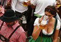 Гостья фестиваля пьет пиво на открытии Октоберфест в Мюнхене Гостья фестиваля пьет пиво на открытии Октоберфест в Мюнхене