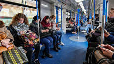 Пассажиры в вагоне поезда московского метрополитена. Архивное фото Пассажиры в вагоне поезда московского метрополитена. Архивное фото