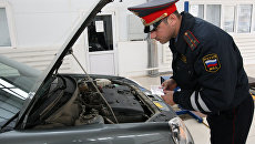 Сотрудник ГИБДД проводит технический осмотр личного автотранспорта. Архивное фото Сотрудник ГИБДД проводит технический осмотр личного автотранспорта. Архивное фото