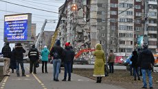 Прохожие наблюдают за ходом работ служб МЧС РФ по расчистке завалов частично обрушившегося жилого панельного дома на Удмуртской улице в Ижевске. Архивное фото Прохожие наблюдают за ходом работ служб МЧС РФ по расчистке завалов частично обрушившегося жилого панельного дома на Удмуртской улице в Ижевске. Архивное фото