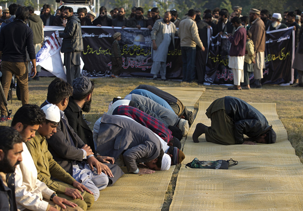 Сторонники пакистанской религиозной партии молятся перед антиамериканским митингом в Исламабаде. 7 декабря 2017