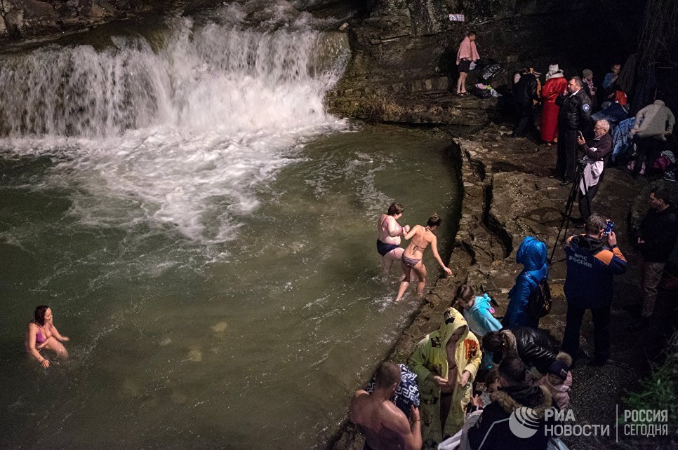 Верующие во время традиционного праздничного купания в Крещенский сочельник в водопадах реки Жане у города Геленджик в Краснодарском крае
