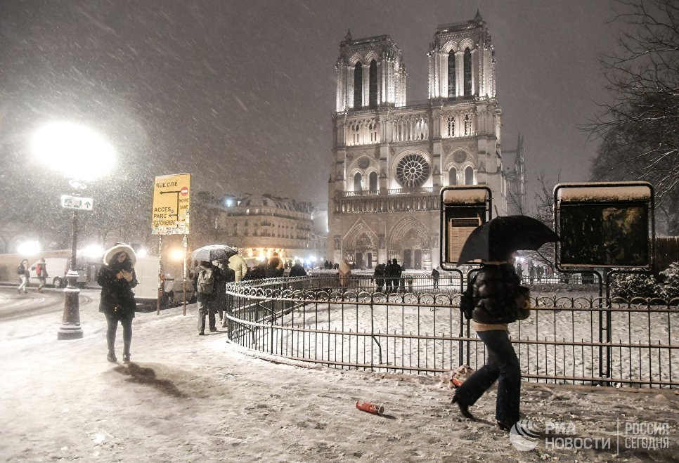 Прохожие возле Собора Парижской Богоматери (Notre-Dame de Paris) во время снегопада в Париже