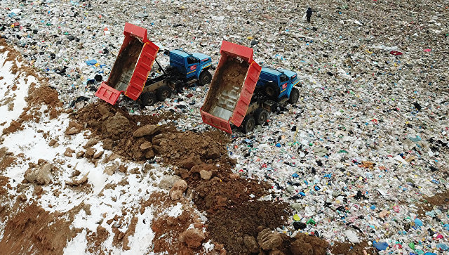 Сотрудники полигона твердых бытовых отходов Ядрово в Московской области засыпают грунтом площадку полигона для нейтрализации неприятных запахов