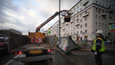 Рабочие грузят рекламный щит, поваленный ураганным ветром на углу Смоленского бульвара и 1-ого Неопалимовского переулка в Москве. 22 апреля 2018 Рабочие грузят рекламный щит, поваленный ураганным ветром на углу Смоленского бульвара и 1-ого Неопалимовского переулка в Москве. 22 апреля 2018