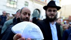Мужчина показывает традиционную еврейскую кипу на мероприятии Berlin wears kippa в Берлине Мужчина показывает традиционную еврейскую кипу на мероприятии Berlin wears kippa в Берлине