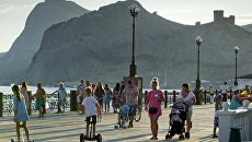Отдыхающие прогуливаются по набережной в Судаке Отдыхающие прогуливаются по набережной в Судаке