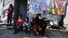 Женщина с детьми в палаточном лагере для сирийских беженцев долине Бекаа в Ливане. Архивное фото Женщина с детьми в палаточном лагере для сирийских беженцев долине Бекаа в Ливане. Архивное фото