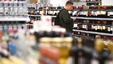 Покупатель в отделе алкогольной продукции. Архивное фото Покупатель в отделе алкогольной продукции. Архивное фото