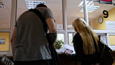 Оформление документов на автомобиль в отделении ГИБДД. Архивное фото Оформление документов на автомобиль в отделении ГИБДД. Архивное фото