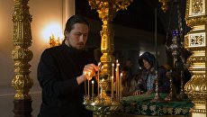 Монах зажигает лампады у раки с мощами святых Сергия и Германа в день церковного празднования памяти валаамских чудотворцев преподобных Сергия и Германа Монах зажигает лампады у раки с мощами святых Сергия и Германа в день церковного празднования памяти валаамских чудотворцев преподобных Сергия и Германа