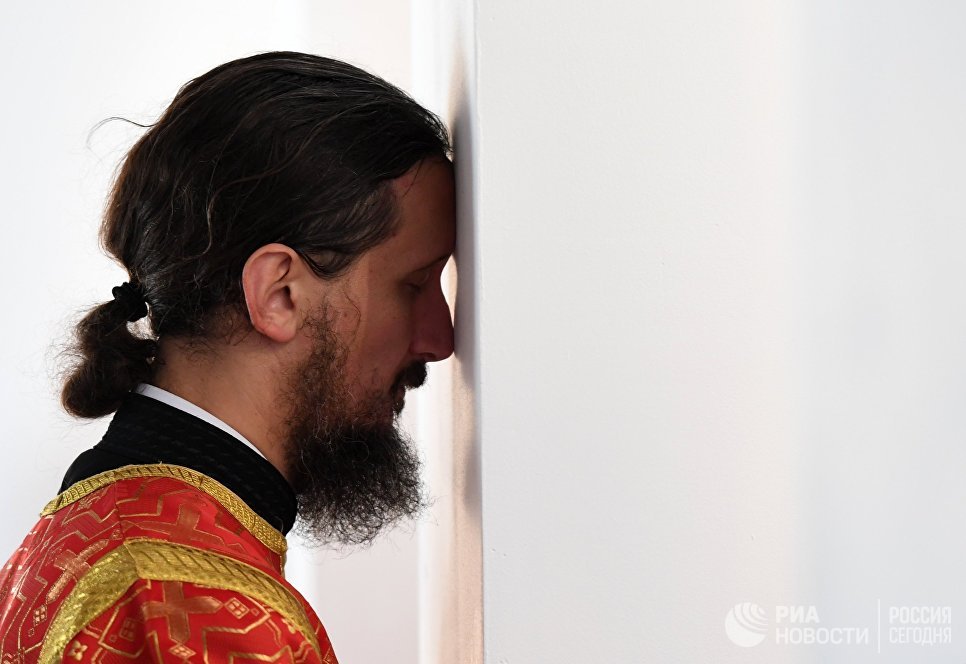 Священнослужитель во время освящения храма Федоровской иконы Божией матери Священнослужитель во время освящения храма Федоровской иконы Божией матери