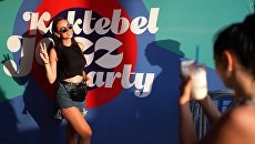 Девушка фотографируется у баннера музыкального фестиваля Koktebel Jazz Party 2018 Девушка фотографируется у баннера музыкального фестиваля Koktebel Jazz Party 2018