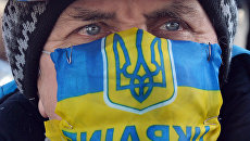 Участник акции протеста в маске с изображением флага и герба Украины в Киеве. Архивное фото Участник акции протеста в маске с изображением флага и герба Украины в Киеве. Архивное фото