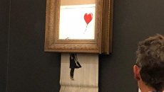 Работа художника Бэнкси Девочка с шаром во время самоуничтожения на аукционе Sotheby's в Лондоне Работа художника Бэнкси Девочка с шаром во время самоуничтожения на аукционе Sotheby's в Лондоне