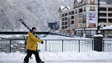 Отдыхающий с лыжами на горнолыжном курорте Роза хутор в Сочинском Национальном Парке. Архивное фото Отдыхающий с лыжами на горнолыжном курорте Роза хутор в Сочинском Национальном Парке. Архивное фото